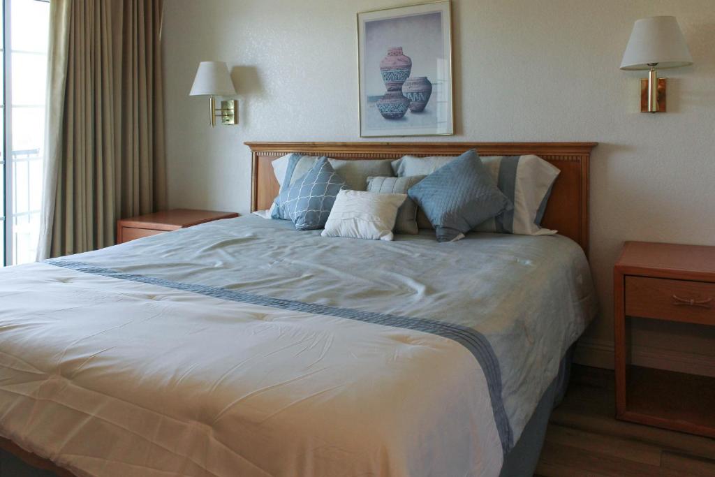 a bedroom with a large white bed with blue pillows at lodge on the river in Bullhead City