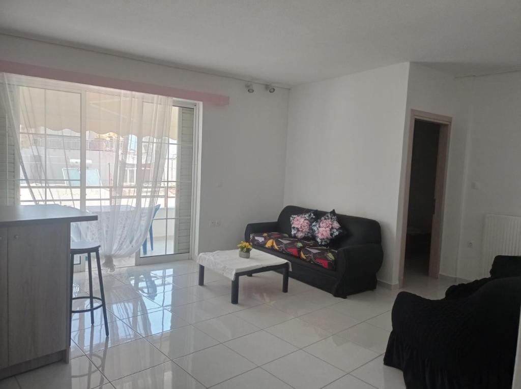 ein Wohnzimmer mit einem schwarzen Sofa und einem Tisch in der Unterkunft Pireas view in Piräus