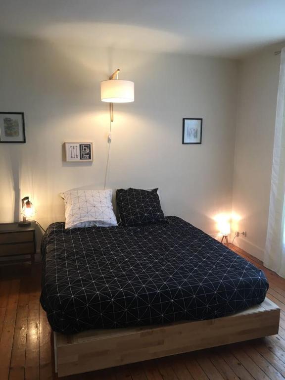 - une chambre avec un lit et une couette noire dans l'établissement ANTONY Centre à 150m du RER Antony, des commerces et du marché., à Antony