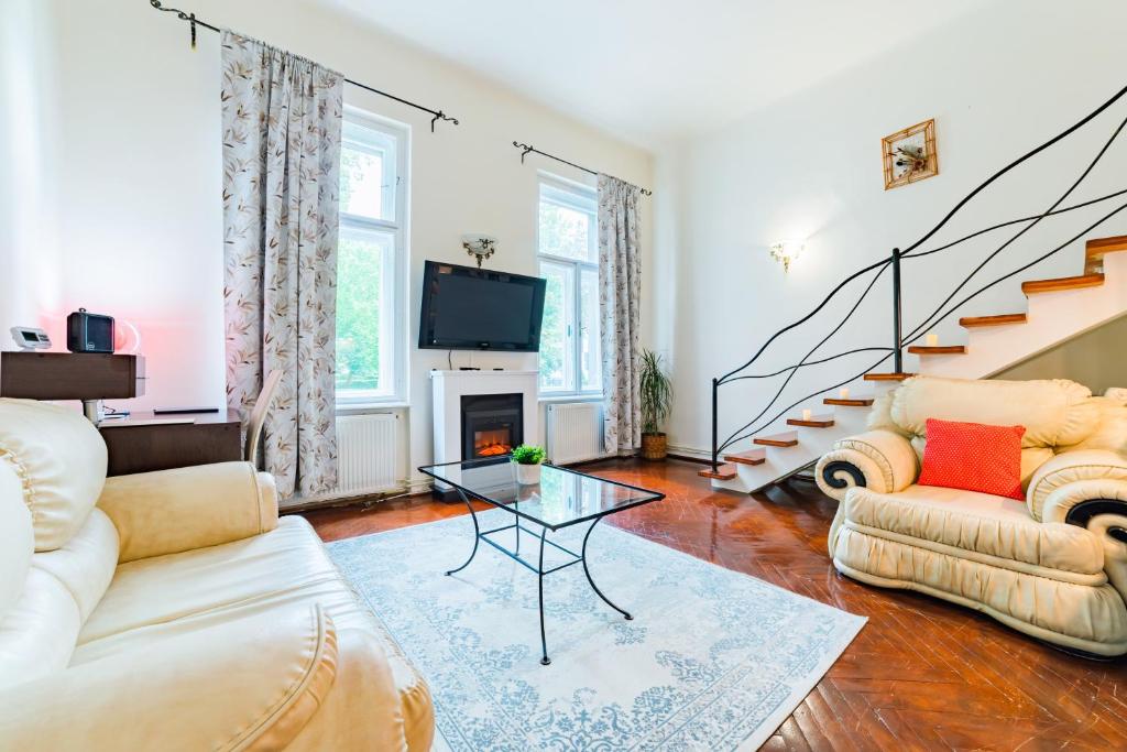 a living room with two couches and a tv at Sabin Apartments Private Parking in Braşov