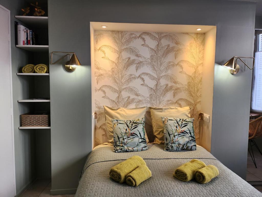 - une chambre avec un lit et 2 oreillers jaunes dans l'établissement Ambiance raffinée cœur de ville, à Dijon