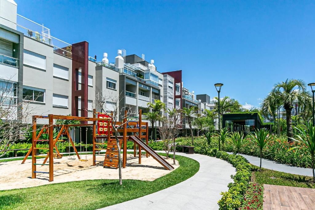un parque infantil en un parque frente a un edificio en Apto no cond Thai Beach Home Spa frente mar TBS106, en Florianópolis