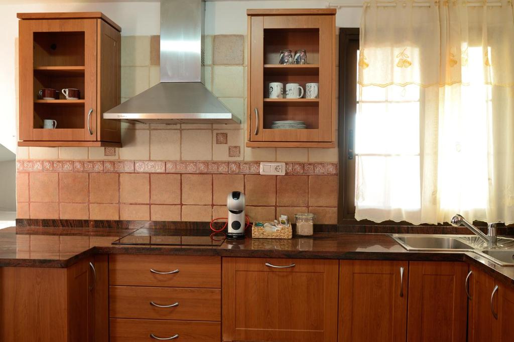 una cocina con armarios de madera y fregadero en La Casa de Las Flores, en Tacoronte