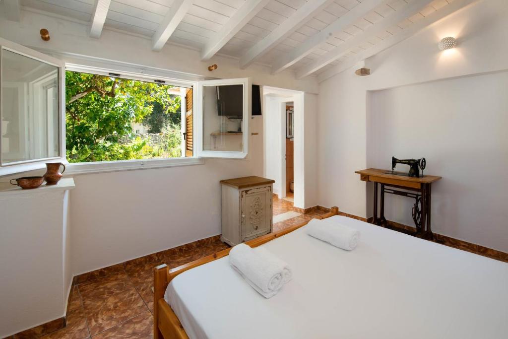 um quarto com 2 camas e uma janela em Aphrodite's hidden gem on Paxos island em Velianitátika