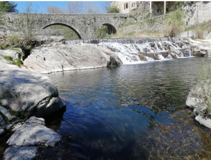 un ruisseau d'eau avec un pont en arrière-plan dans l'établissement Maison sur la rivière, à Lasalle