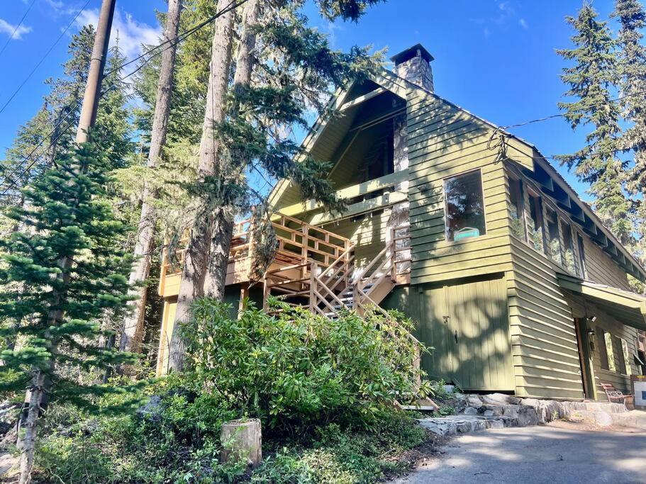 una casa amarilla con porche y árbol en Camp Creek Hideaway Modern Cascades Haven for 12, en Government Camp