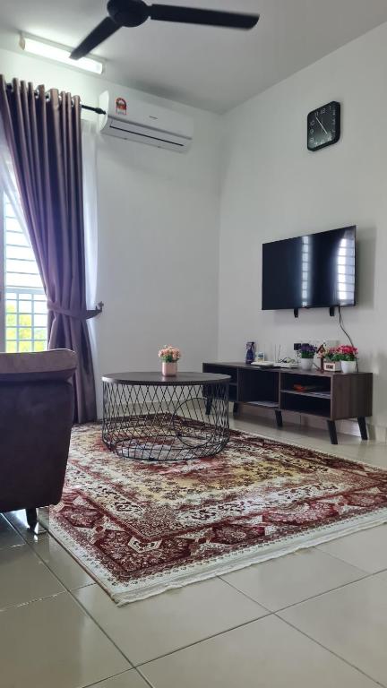 a living room with a table and a tv at Alanis Suite KLIA With Neflix & Airport Shuttle in Sepang