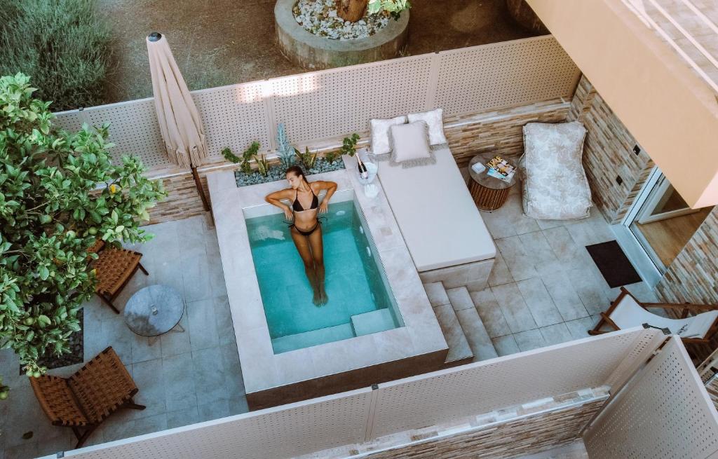 an overhead view of a woman in a swimming pool at Sabbia Mini Pool Suites in Preveza