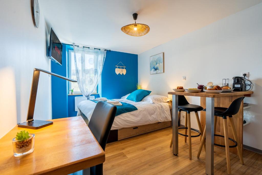 a bedroom with a bed and a desk and a table at Le Roqueprins - Netflix/Wi-Fi Fibre/Terrasse in Banassac
