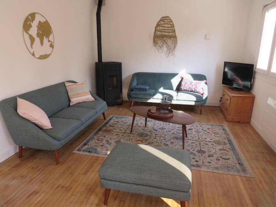 a living room with a couch and a table at Maison - plage à pied in Frehel