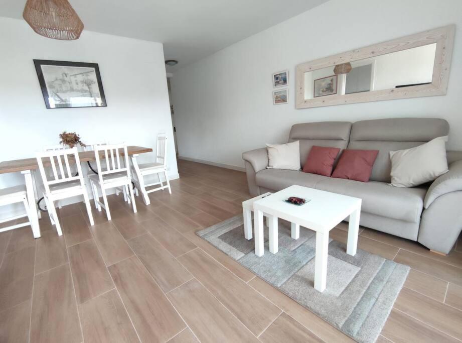 a living room with a couch and a table at Amplio apartamento con piscina al lado de la playa in Platja d'Aro