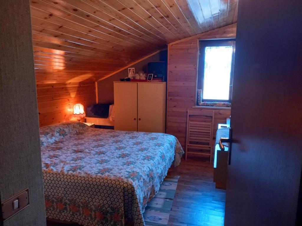 1 dormitorio con 1 cama en una habitación de madera en In mezzo al bosco, en Salerni