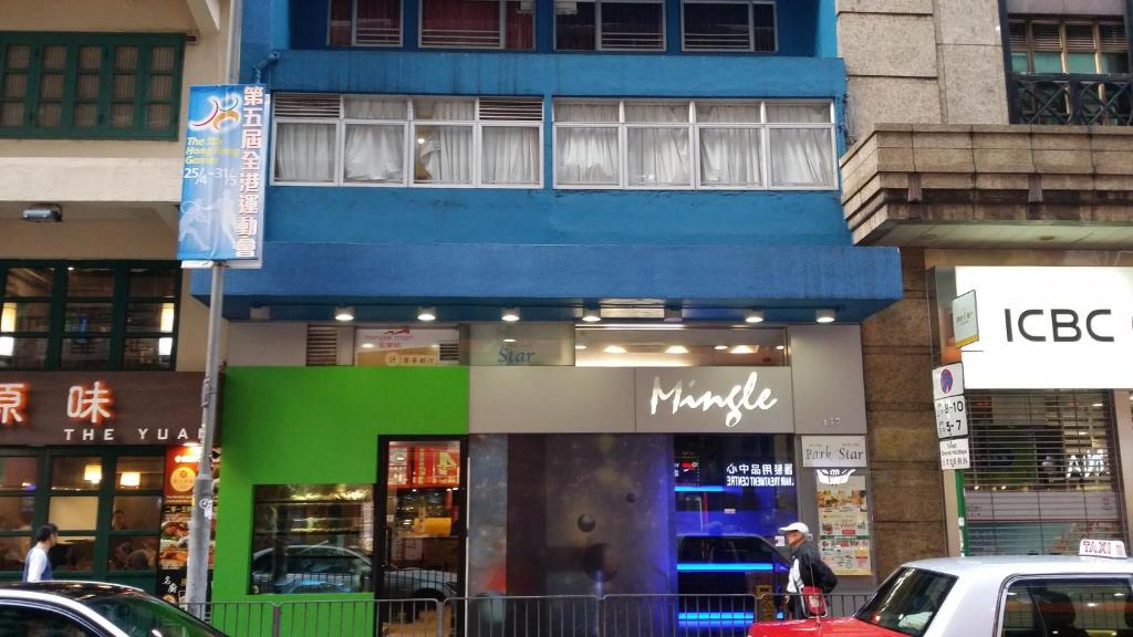 um edifício azul e verde numa rua da cidade em Mingle With The Star em Hong Kong
