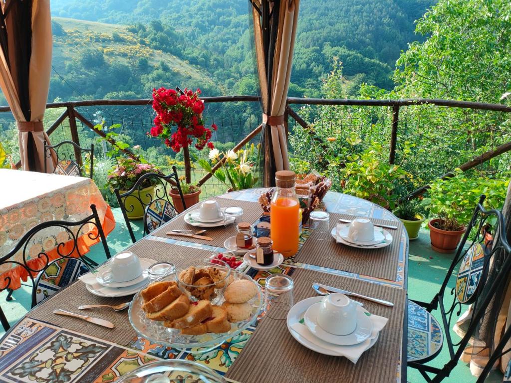 a table with a breakfast of bread and orange juice at B&B Il Ghiro-Country House in Mormanno