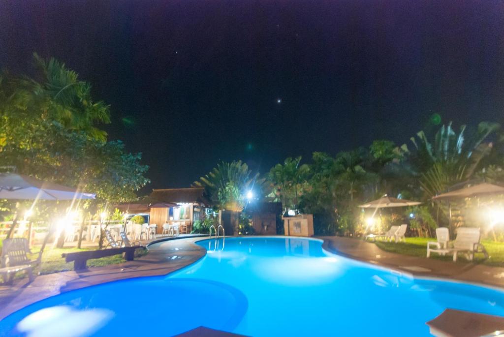 a large swimming pool at night with lights at Namkhong Guesthouse and Resort in Chiang Khong