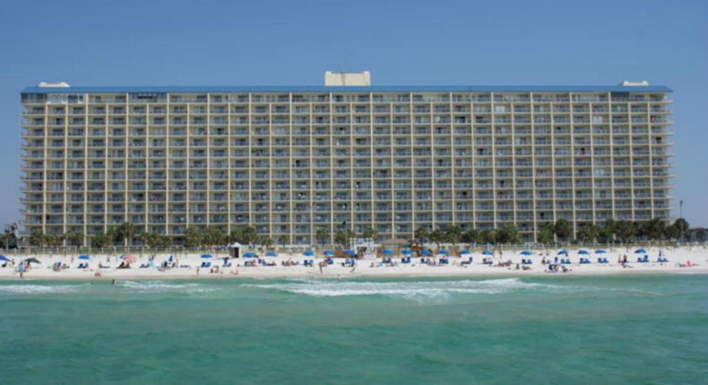 a large building on the beach with people on the beach at The Summit Condominiums in Panama City Beach