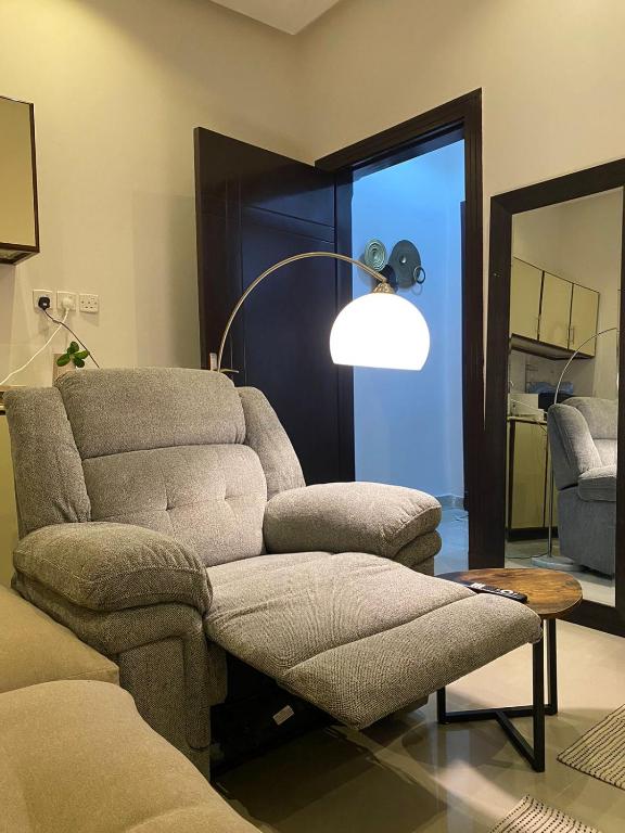 uma sala de estar com um sofá, uma cadeira e um candeeiro em شقة مدخل خاص دخول ذاتي em Riyadh
