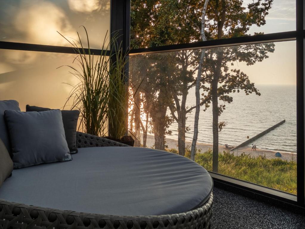 a bed in a room with a view of the ocean at Blow up Baltic Trzęsacz in Trzęsacz