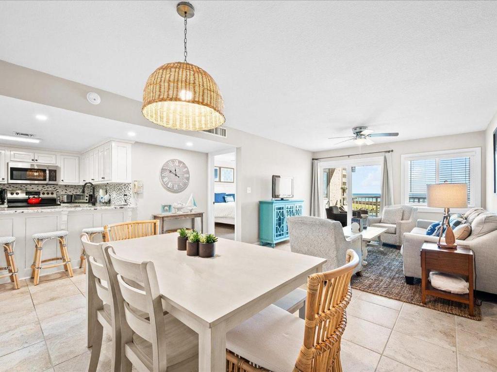 cocina y sala de estar con mesa y sillas en Holiday Surf and Racquet Unit 207, en Destin