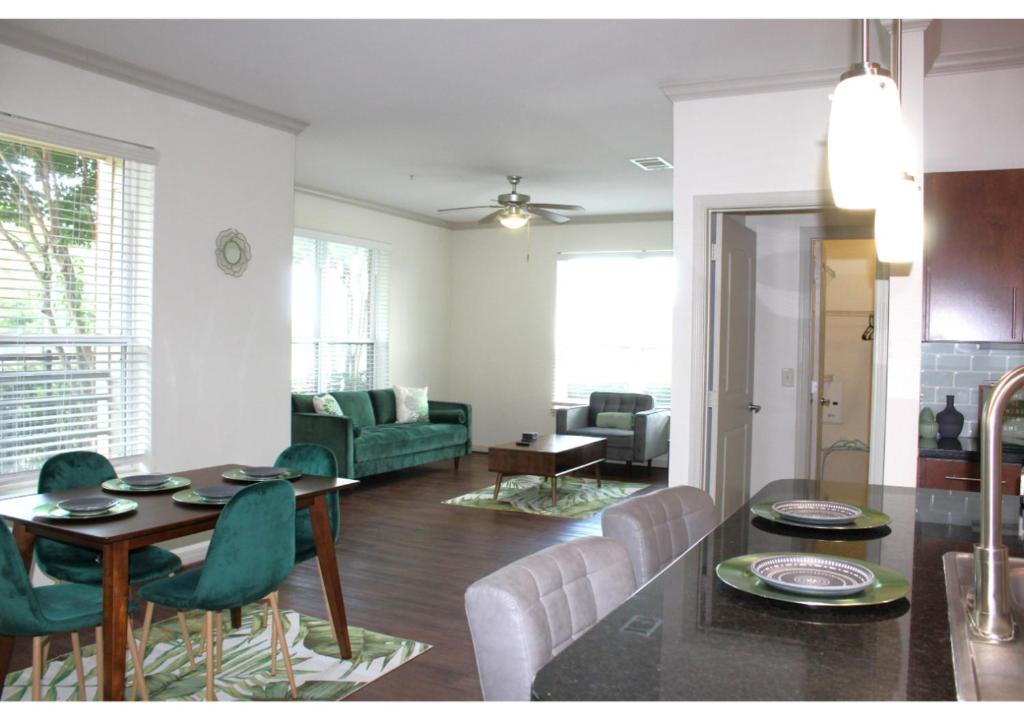 een eetkamer en een woonkamer met een tafel en stoelen bij The Jasmine Garden Apt - Poolview in Houston