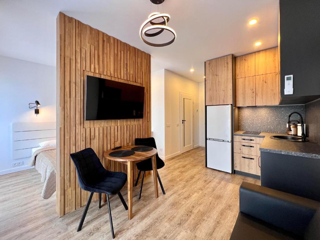 a kitchen with a table and chairs and a refrigerator at TideHaven in Palanga