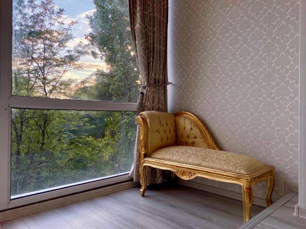 a chair sitting in front of a large window at Downtown Studio - Ultra Central with Park View in Bucharest