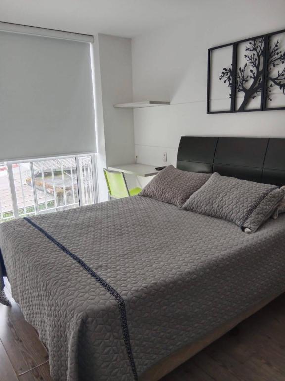 - un grand lit dans une chambre avec une grande fenêtre dans l'établissement ¡Excelente opción de apartaloft en Pereira! Piso 3, à Pereira