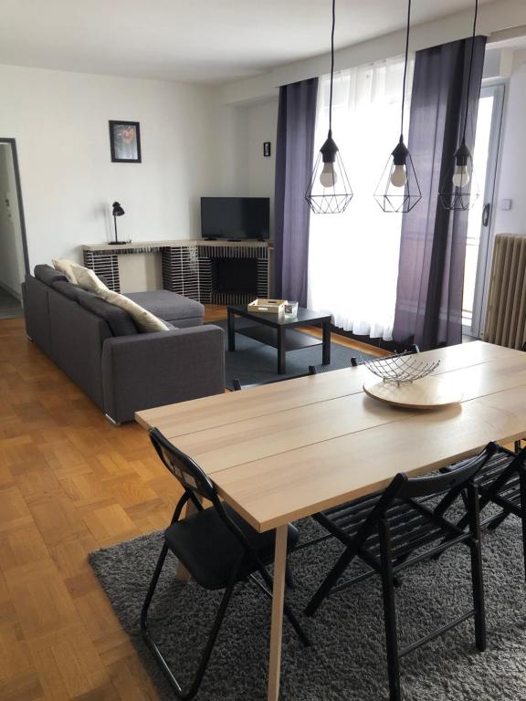 un salon avec une table en bois et un canapé dans l'établissement Grand Appartement Privatif, à Châteauroux