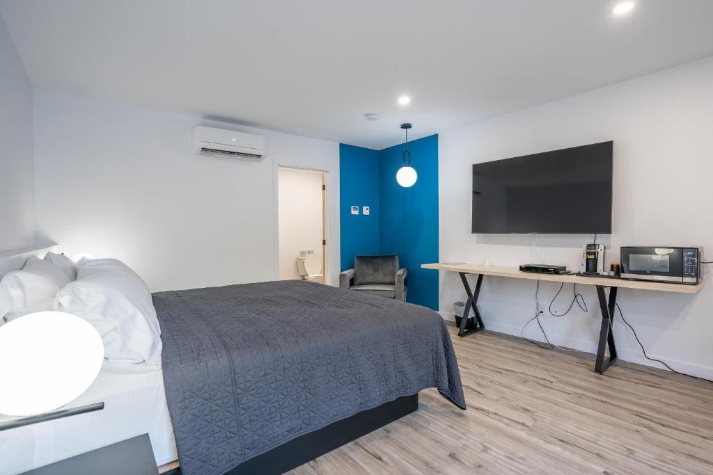 - une chambre avec un lit et un bureau avec une télévision dans l'établissement Le 2020 Charlevoix, à La Malbaie