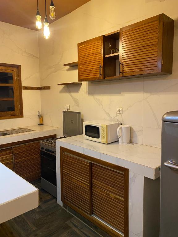 a kitchen with a microwave on top of a counter at Keur royal in Dakar