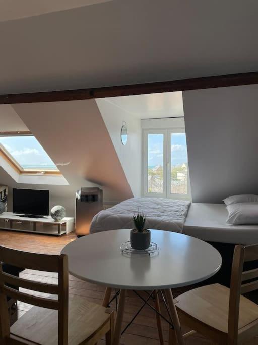 - une chambre avec un lit, une table et une table dans l'établissement Donville vue sur la mer, à Donville-les-Bains