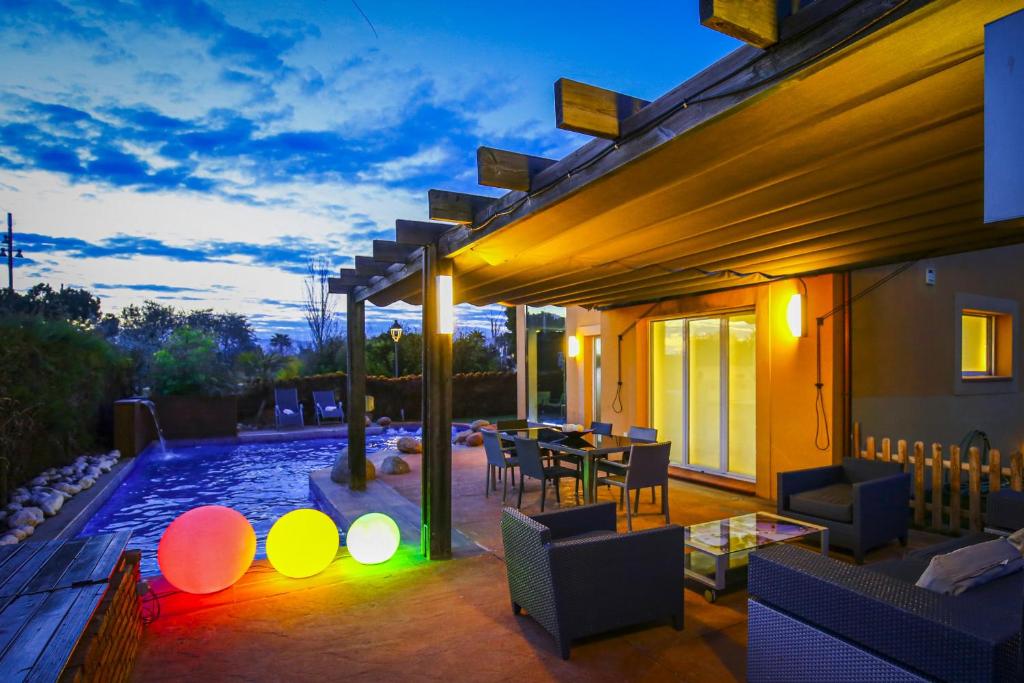 a patio with a table and chairs and a swimming pool at LUXEZEN Planetcostadorada in Reus