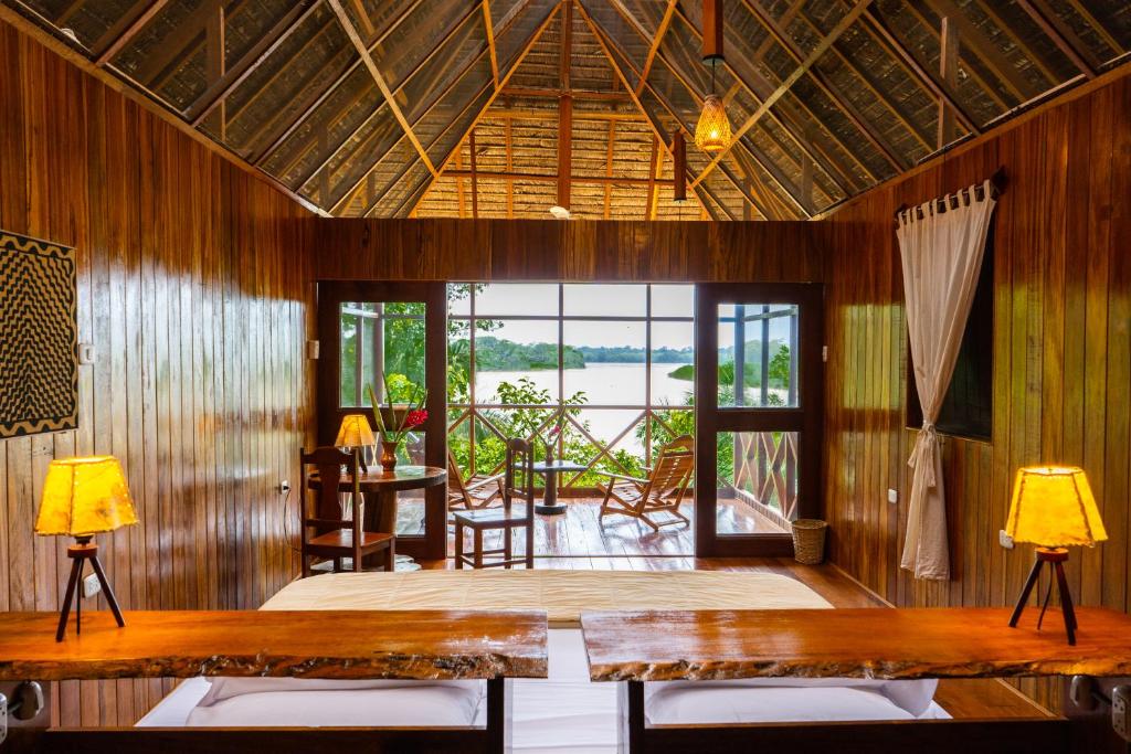 sala de estar con mesa y sillas y patio en Sotupa Eco Lodge, en Puerto Maldonado