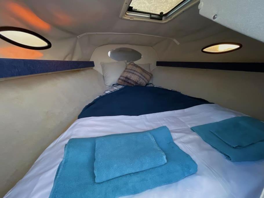 a bed in the back of a van with two pillows at GuestBoat Milagre in Faro