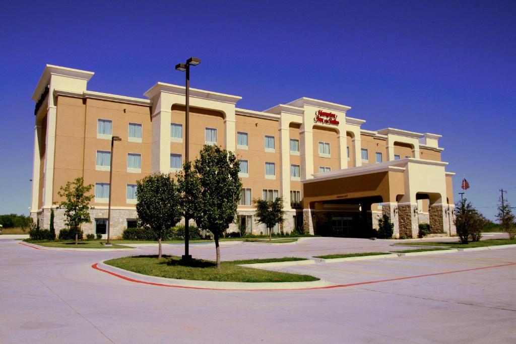 un edificio de hotel con un árbol delante de él en Hampton Inn & Suites Abilene I-20, en Abilene