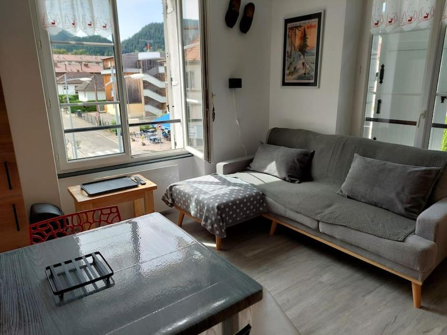 a living room with a couch and a table at L'escale du centre du lac de Gérardmer in Gérardmer