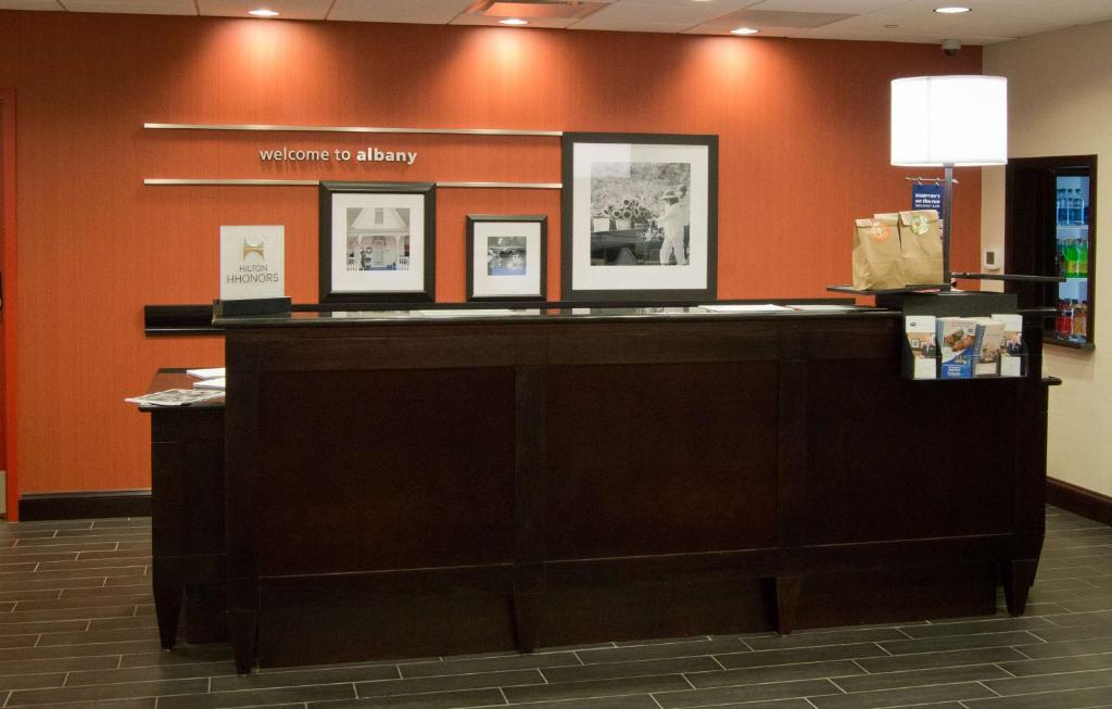 a reception desk in a library with pictures on the wall at Hampton Inn & Suites Albany at Albany Mall in Albany