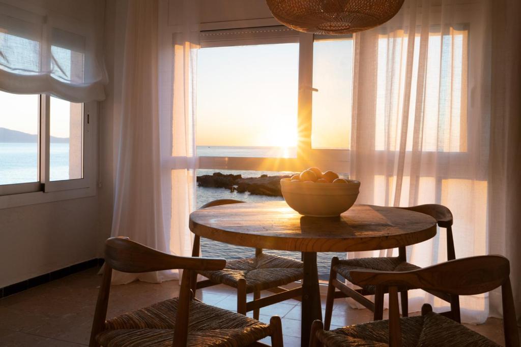 una mesa y sillas con un bol de fruta. en Casa tres vents, en L'Escala