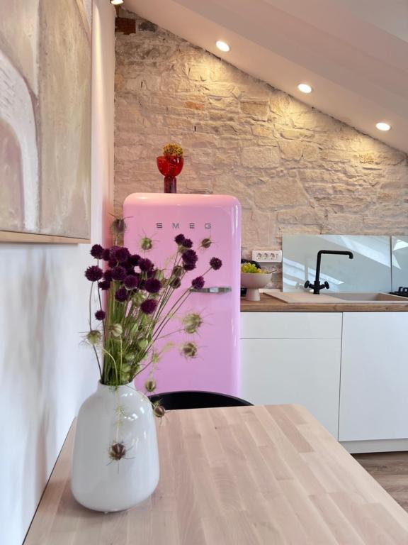 un vase avec des fleurs sur une table dans une cuisine dans l'établissement Apartments Forum 2, à Pula