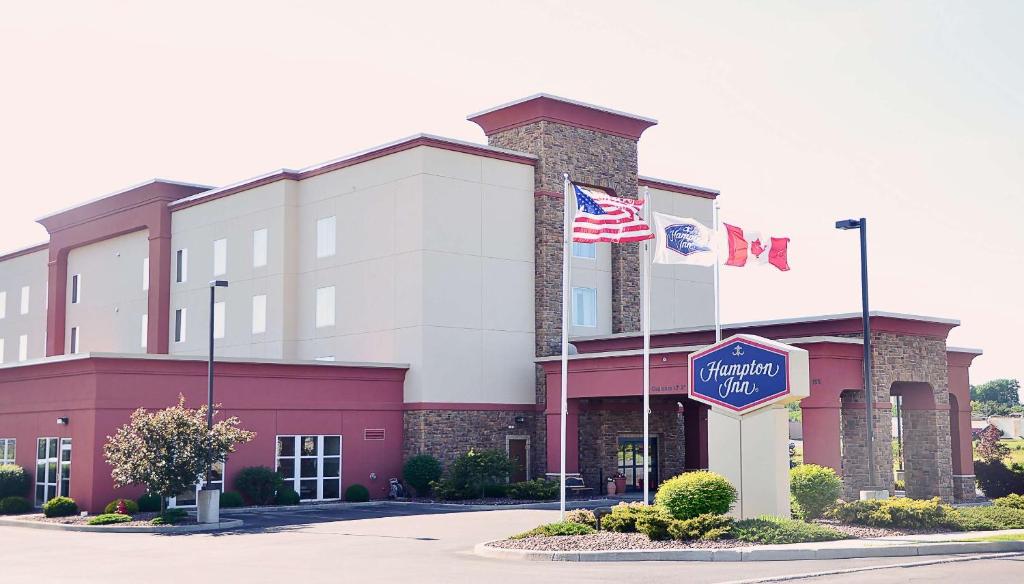 an office building with two flags in front of it at Hampton Inn Watertown in Watertown