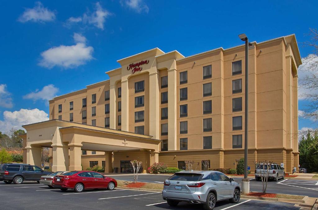 a hotel building with cars parked in a parking lot at Hampton Inn Covington in Covington