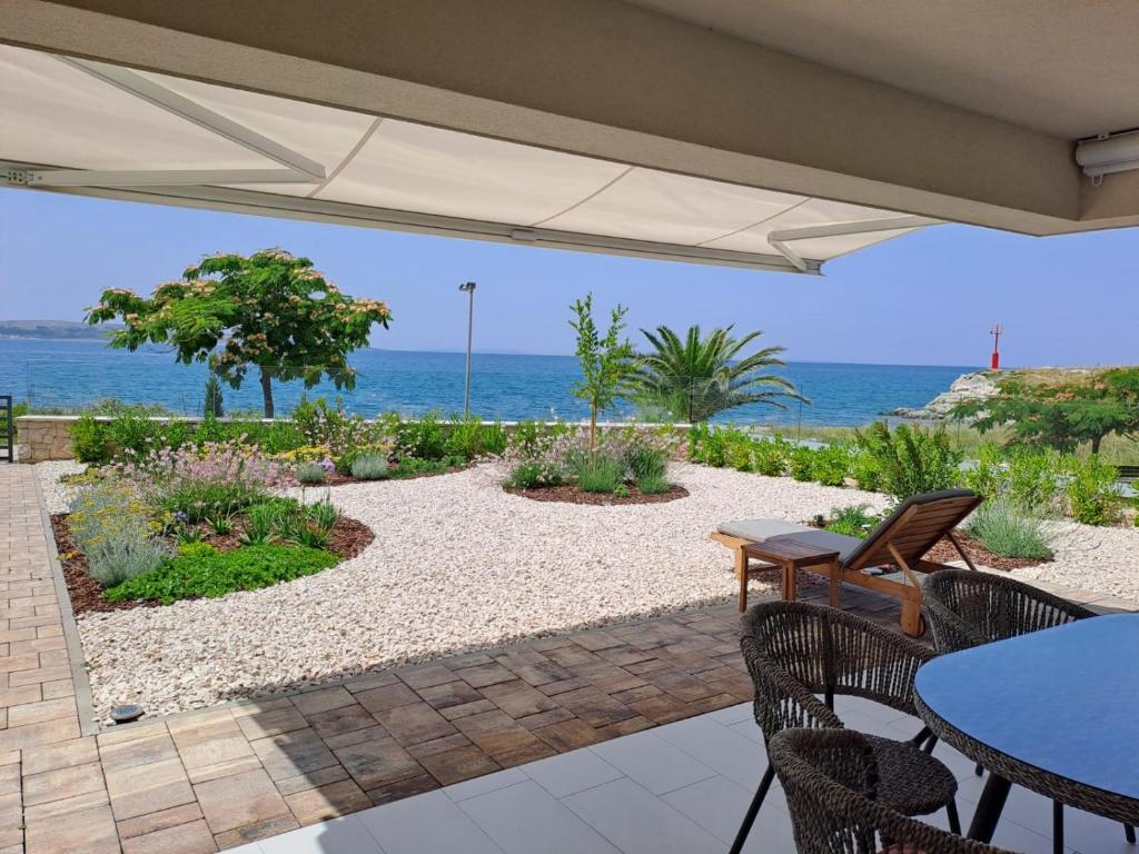 a patio with a table and chairs and the ocean at La Mar in Pag