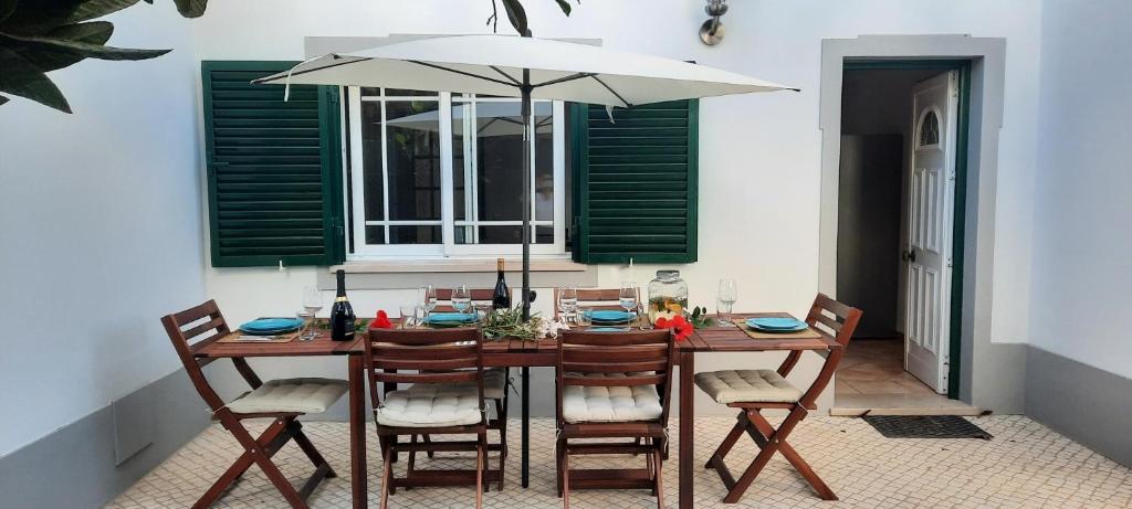 a wooden table with chairs and an umbrella at Villa Pretty in Almancil