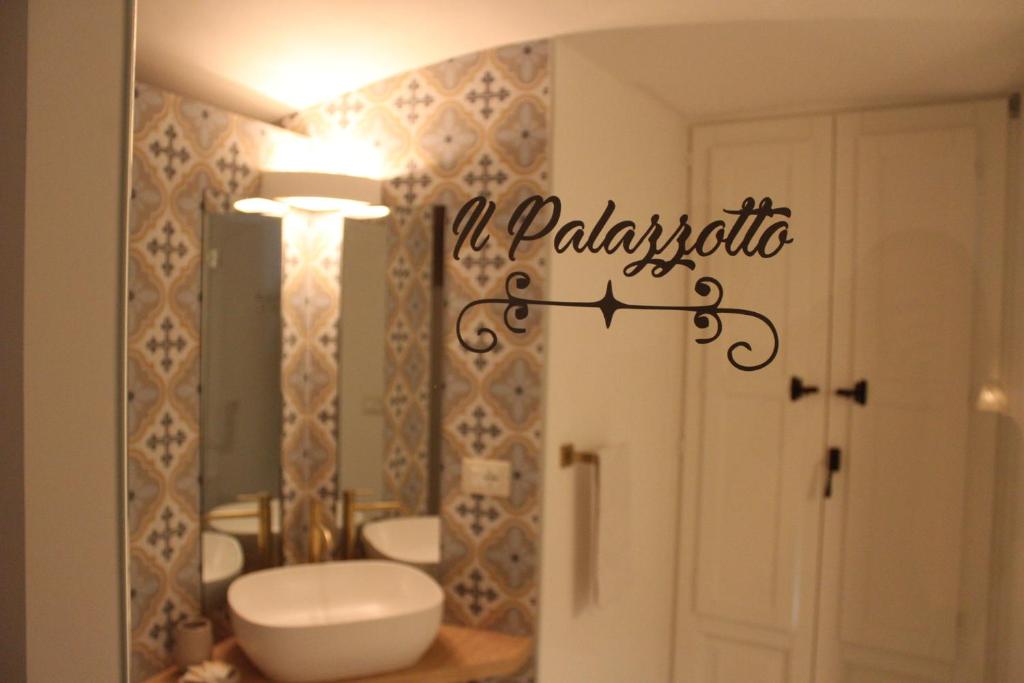 a bathroom with a toilet and a sink and a mirror at Il Palazzotto in Fasano