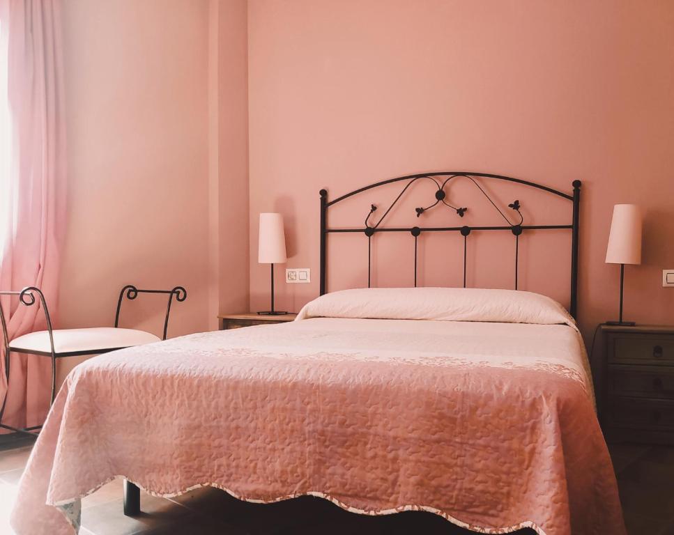 カベズエラデルバレにあるEl Balcon De Cabezuela Valle del Jerteのベッドルーム1室(大型ベッド1台、ランプ2つ付)