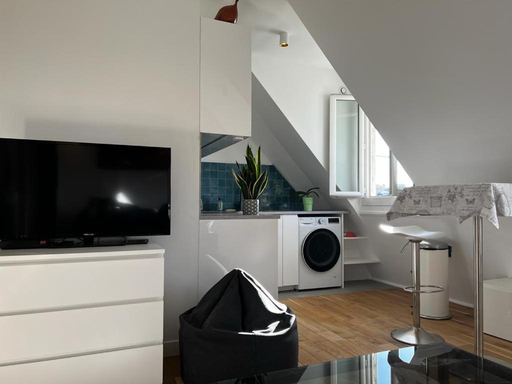 Il comprend un salon blanc doté d'une télévision et d'un lave-linge. dans l'établissement Appartement Paris 16eme, à Paris