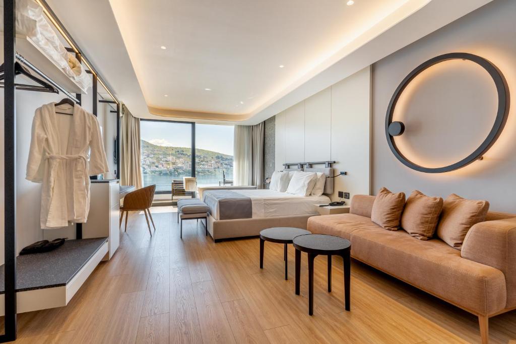 a hotel room with a bed and a large mirror at Yacht Premium Hotel in Sarandë