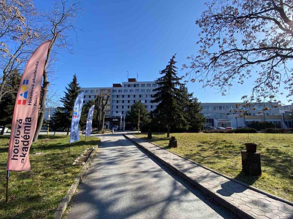 eine Straße mit einem Banner in einem Park mit einem Gebäude in der Unterkunft Garni Hotel Akadémia in Košice