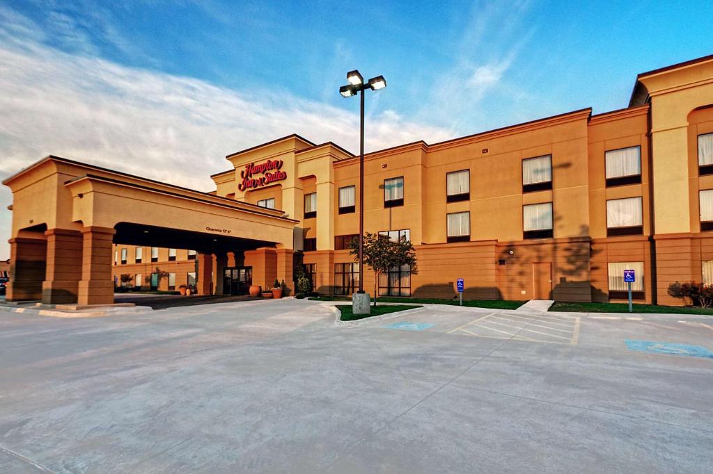 a large building with a parking lot in front of it at Hampton Inn & Suites Altus in Altus