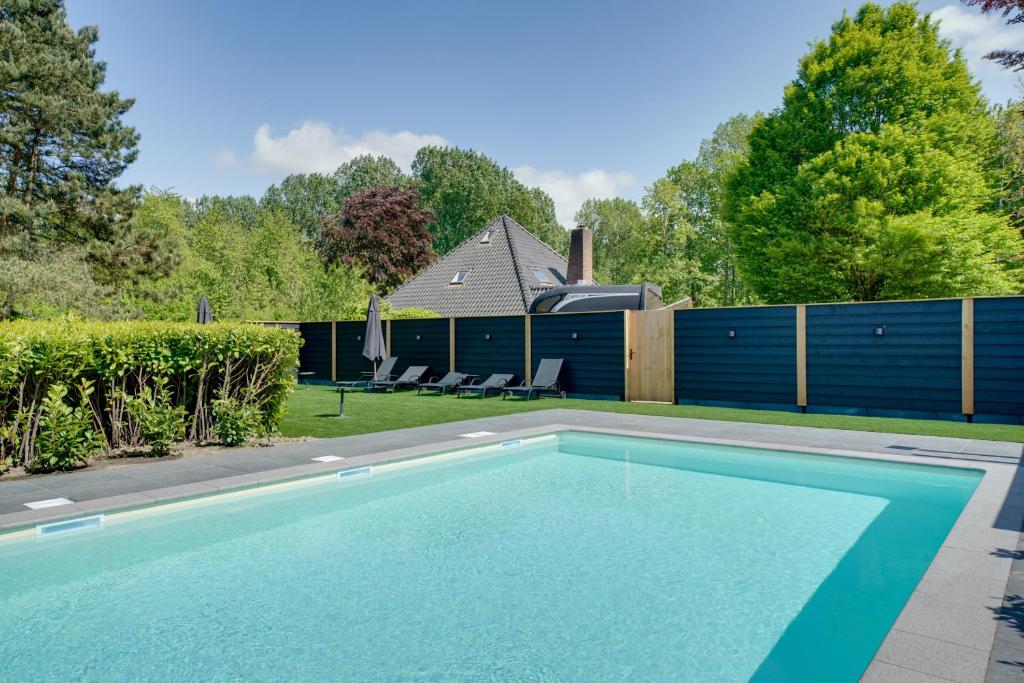 einen Pool im Hinterhof eines Hauses in der Unterkunft Family Villa in Forest with shared pool & Wellness in Zeewolde